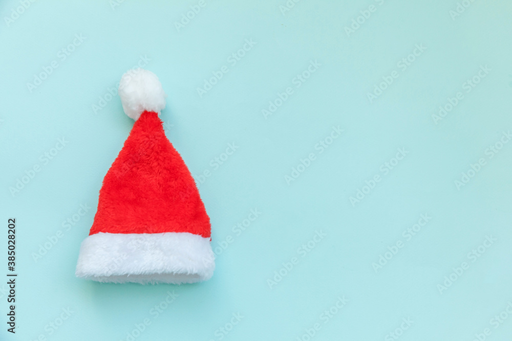 Simply minimal design Christmas Santa Claus hat isolated on blue pastel colorful trendy background. Christmas New Year december time for celebration concept. Flat lay top view copy space