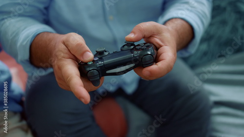 Senior man hands playing game with joystick. Male hands using gamepad for game