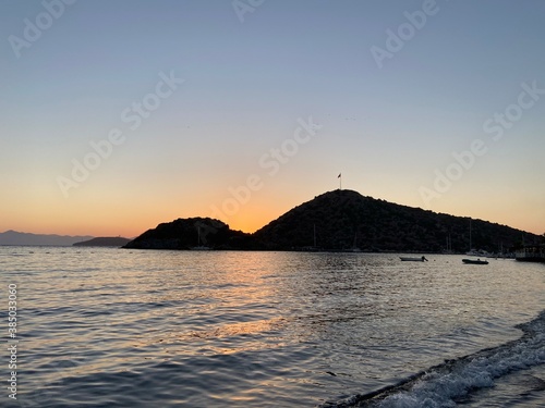 Beautiful sea view at sunset, colorful at dawn, reflections on the sea, sun shades, lights and islands on the aegean sea. 
