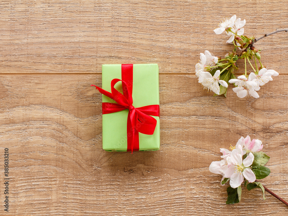 Gift box with cherry flowers on the wooden background. Gift box with cherry flowers on the wooden background.