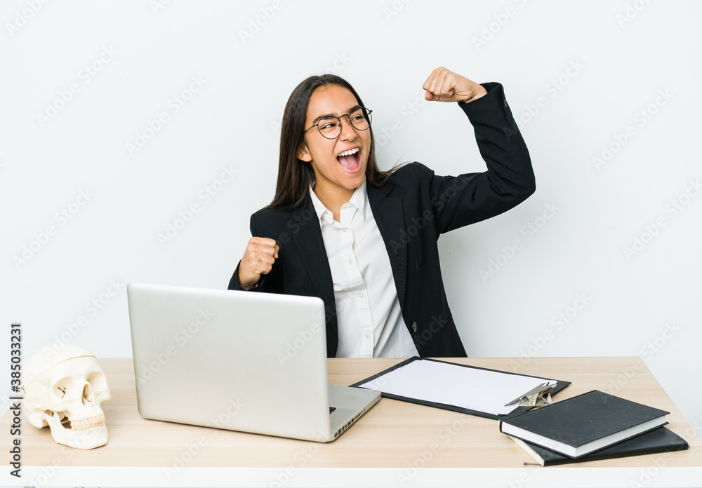 Young traumatologist asian woman isolated on white background raising fist after a victory, winner concept. Young traumatologist asian woman isolated on white background raising fist after a victory, winner concept.