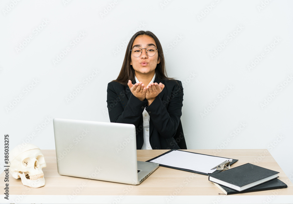 Young traumatologist asian woman isolated on white background folding lips and holding palms to send air kiss. Young traumatologist asian woman isolated on white background folding lips and holding palms to send air kiss.