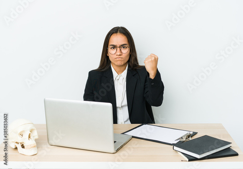 Young traumatologist asian woman isolated on white background showing fist to camera, aggressive facial expression. © Asier