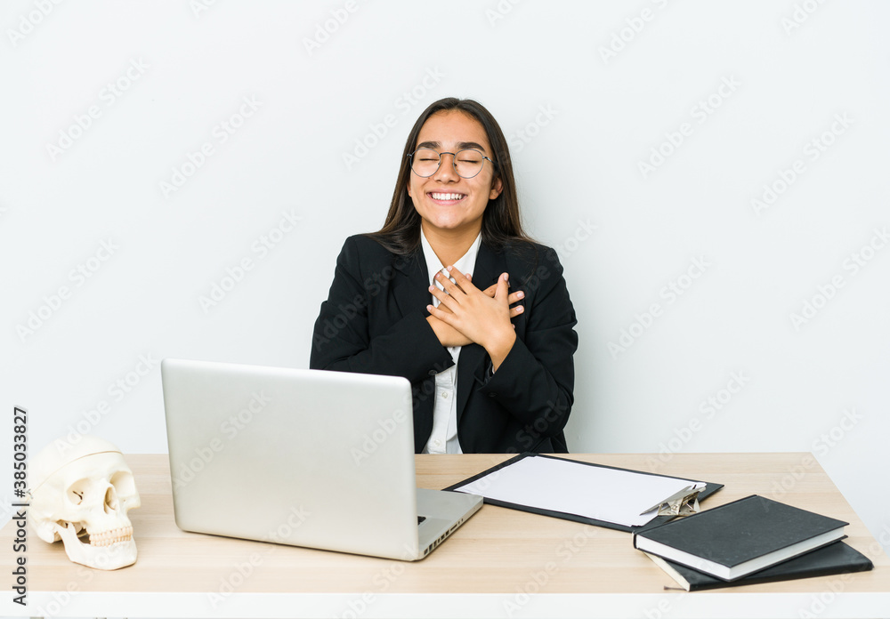 Young traumatologist asian woman isolated on white background laughing keeping hands on heart, concept of happiness. Young traumatologist asian woman isolated on white background laughing keeping hands on heart, concept of happiness.