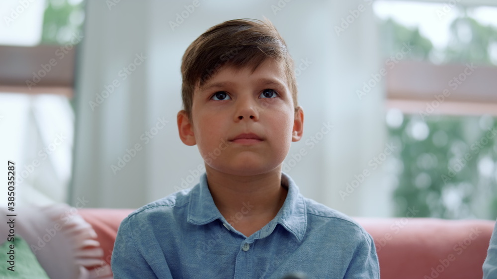 Boy playing computer game with joystick in living room. Gamer using gamepad Boy playing computer game with joystick in living room. Gamer using gamepad