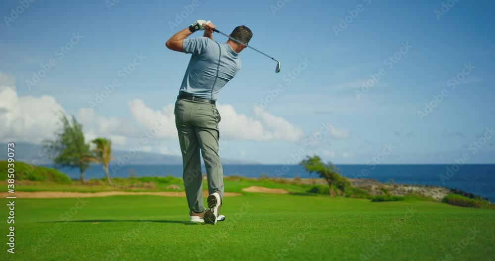Golfer swinging and hitting golf ball on beautiful course by the ocean, slow motion, resort travel vacation concept Golfer swinging and hitting golf ball on beautiful course by the ocean, slow motion, resort travel vacation concept