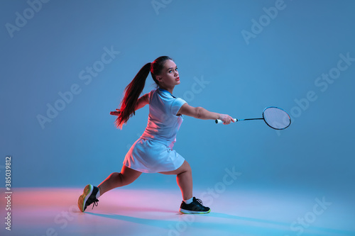 Winner. Beautiful dwarf woman practicing in badminton isolated on blue background in neon light. Lifestyle of inclusive people, diversity and equility. Sport, activity and movement. Copyspace.