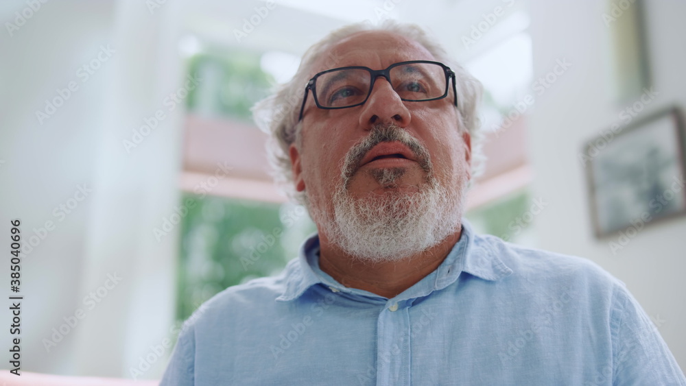 Mature man posing at camera at home. Senior man making surprised emotion Mature man posing at camera at home. Senior man making surprised emotion
