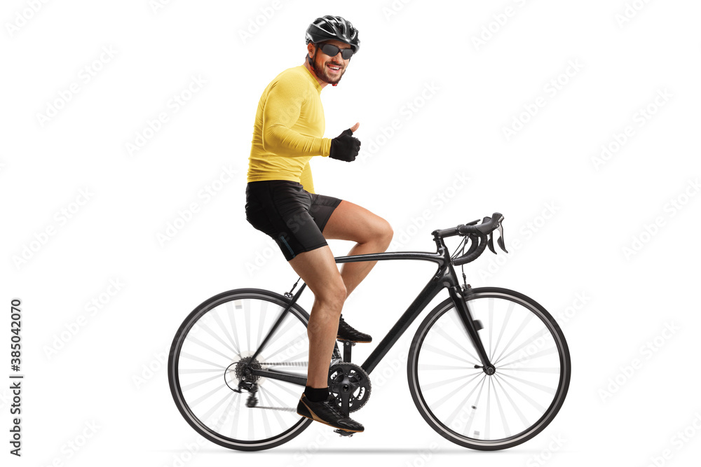 Male cyclist with a helmet riding a road bicycle and showing thumbs up Male cyclist with a helmet riding a road bicycle and showing thumbs up