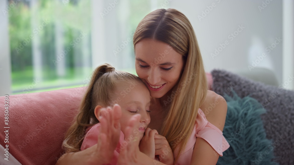 Woman and girl talking in living room. Happy mother and daughter clapping hands Woman and girl talking in living room. Happy mother and daughter clapping hands