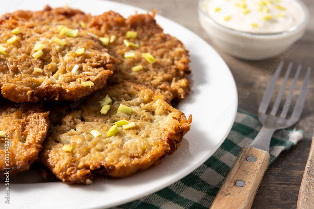 Traditional Jewish latkes or potato pancakes on wooden table Traditional Jewish latkes or potato pancakes on wooden table