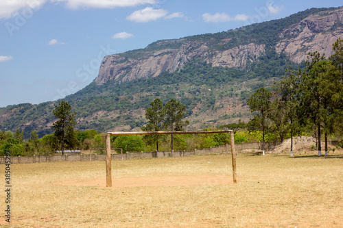 Empty football field with wooden wooden goals in a mountain landscape