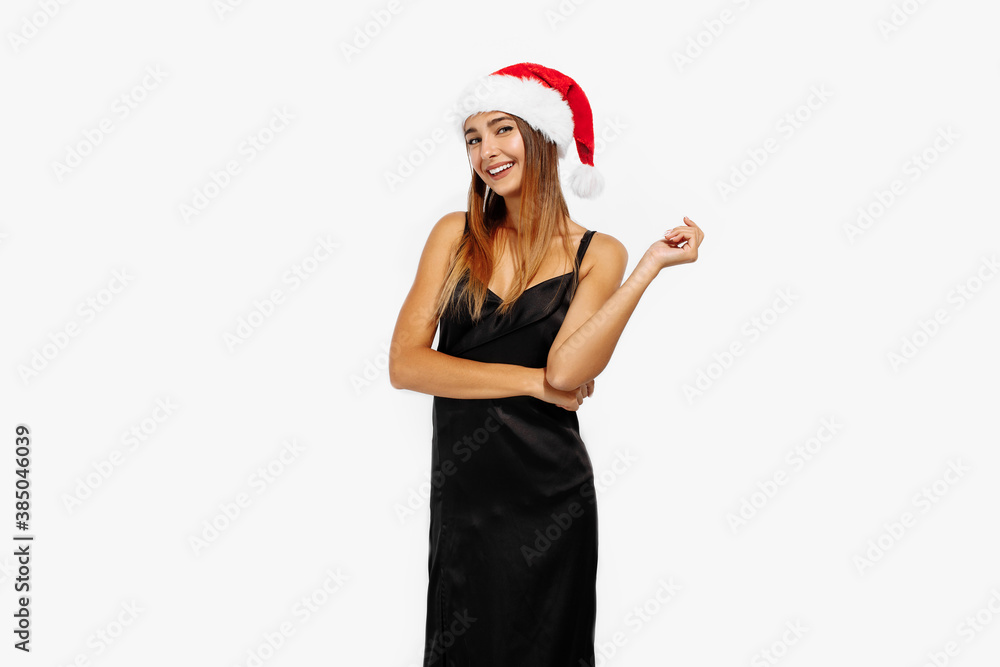 Happy beautiful brunette in Christmas red hat and elegant black dress on white background, holiday concept, Christmas Happy beautiful brunette in Christmas red hat and elegant black dress on white background, holiday concept, Christmas