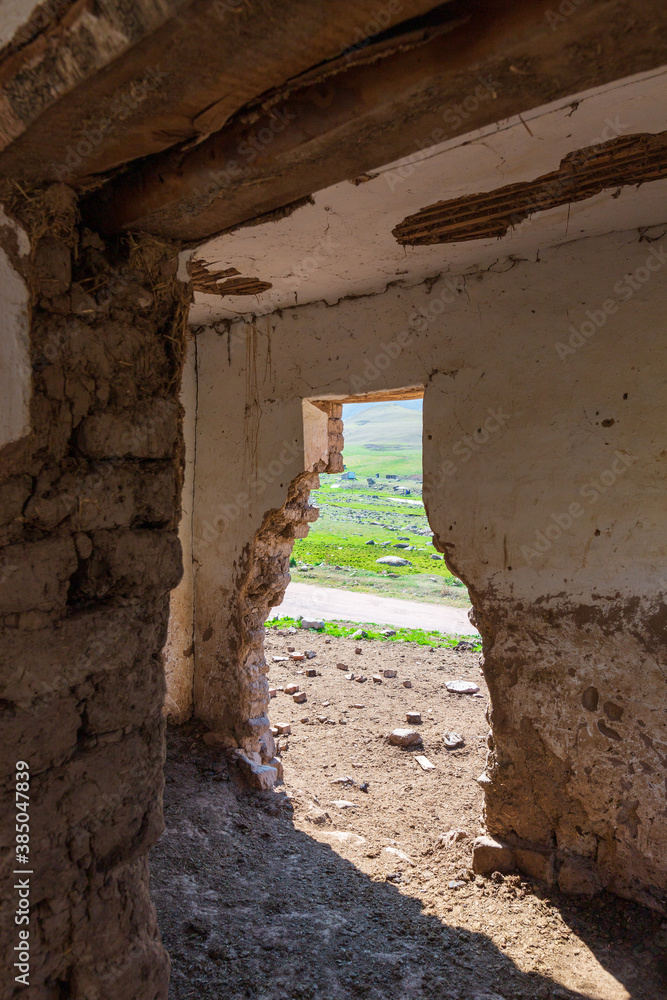 An old abandoned house. No people. The building is made of adobe and wood. House in the mountains of Kyrgyzstan.