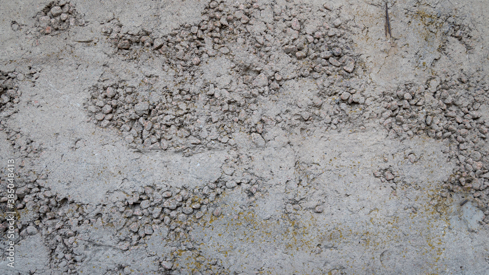 Texture of old reinforced concrete with protruding rusty rebar and moss