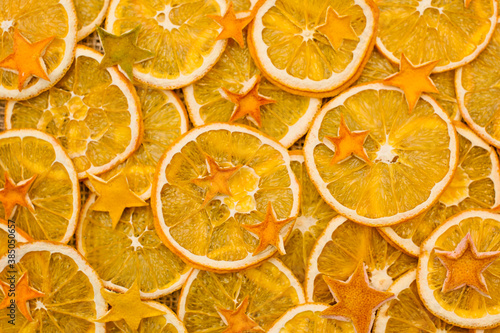 Orange stars made from dried Orange peel. Dried Orange slices on linen cloth. Christmas decoration. Advent ornaments. Ethnographic ornamentation background