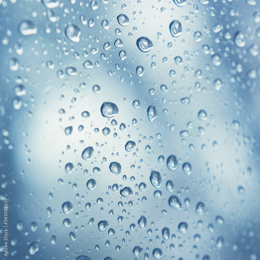 water drops on blue background, close up. Raindrops on the window glass