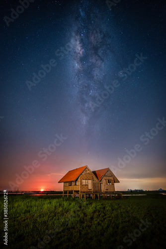 Landscape image of milky way over the abandoned twin house near Chalerm Phra Kiat road in Thale Noi, Phatthalung, Thailand