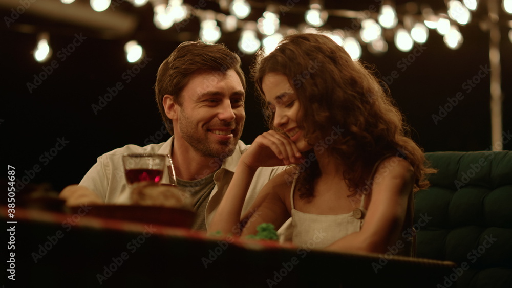 Woman and man having romantic date. Happy couple drinking red wine at table