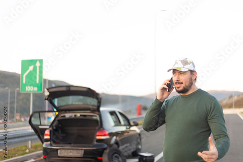 The driver talks on the phone, calls for help on the road. A problem on the trip © Mirnes