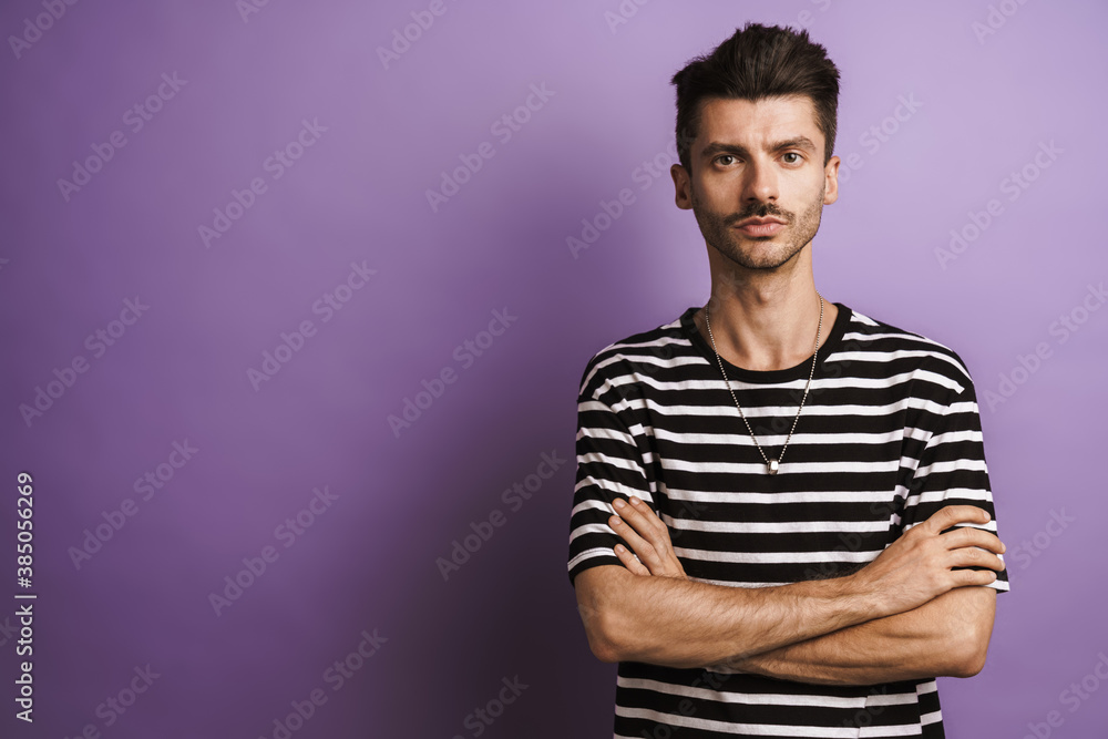 Fototapeta premium Photo of young handsome man posing with arms crossed on camera