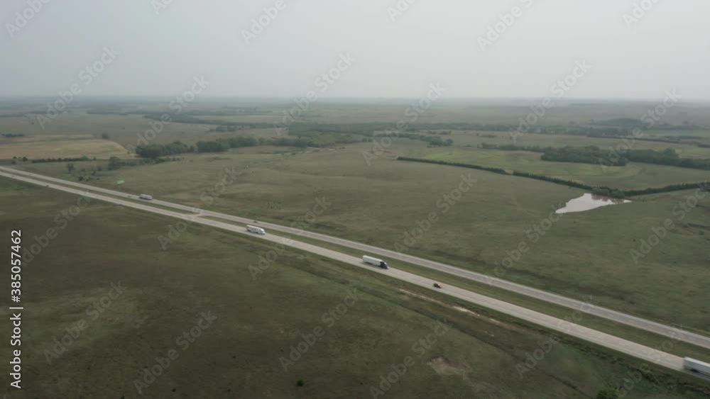 Traffic moves along highway running through Kansas landscape. Aerial reveal. Traffic moves along highway running through Kansas landscape. Aerial reveal.