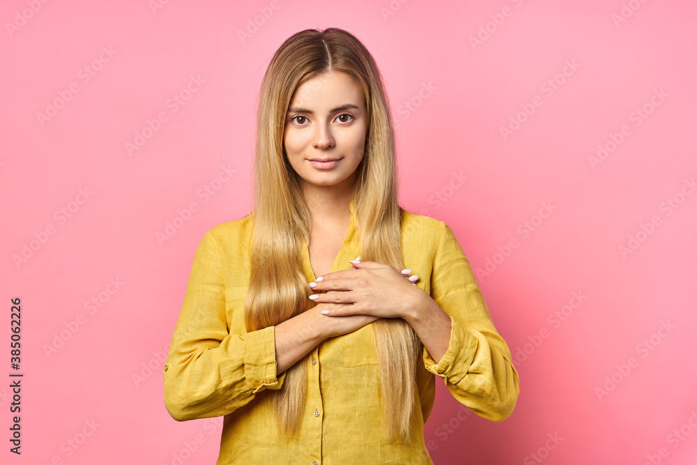 Sensual romantic woman, shows heart or love gesture, smiles happily, expresses affection, isolated on pink wall. Sensual romantic woman, shows heart or love gesture, smiles happily, expresses affection, isolated on pink wall.