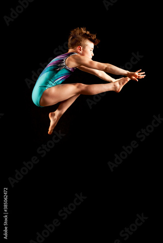 Wallpaper Mural Youth gymnast executing a wolf jump on a black background.  Torontodigital.ca