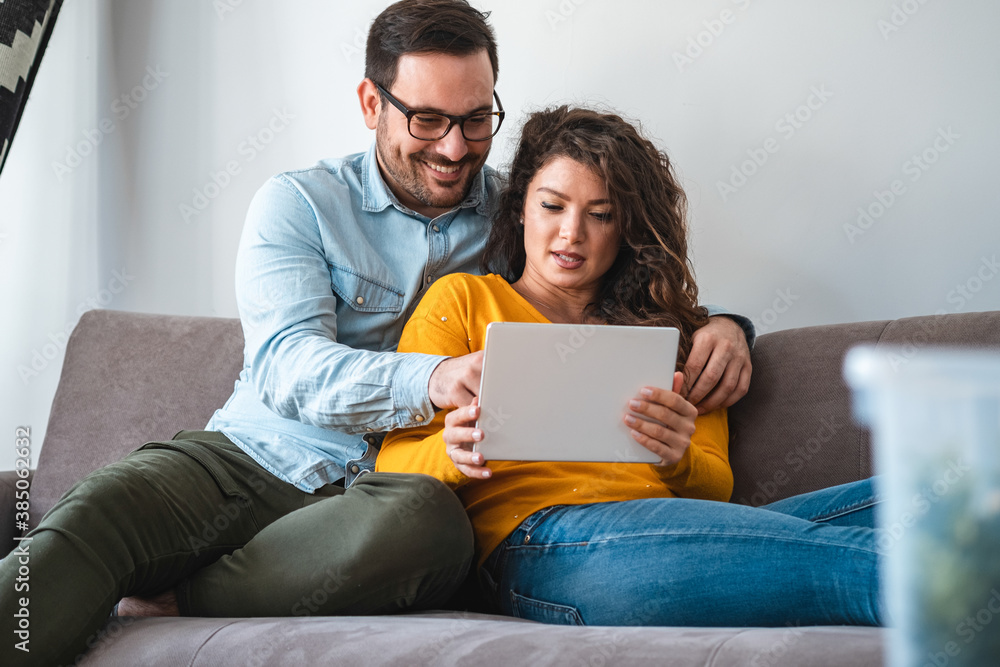 Portrait of smiling couple using tablet together at home stock photo Portrait of smiling couple using tablet together at home stock photo