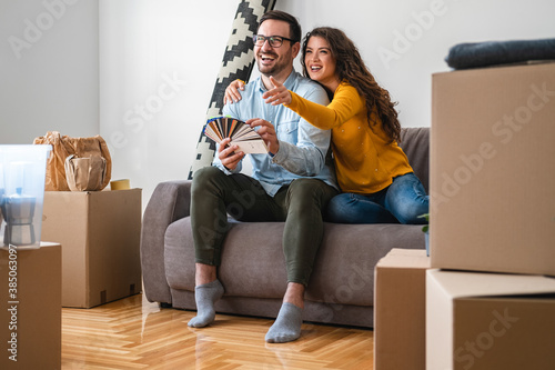 Happy couple choosing new wall color stock photo