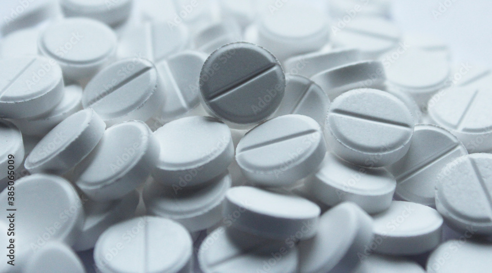 Handful of white pills on white background Handful of white pills on white background