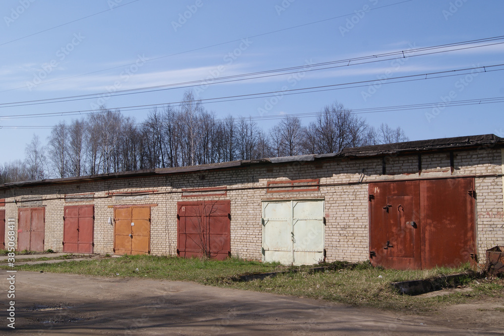 A row of old brick one-story car garages with large metal gates. Garage cooperative since the Soviet Union.