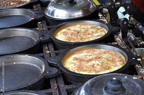 Apam balik or Malaysian Peanut Pancake turnover.  Flour pancake stuffed with sugar and corn topping. Cooked using the hot pan. Famous street food in Malaysia. 