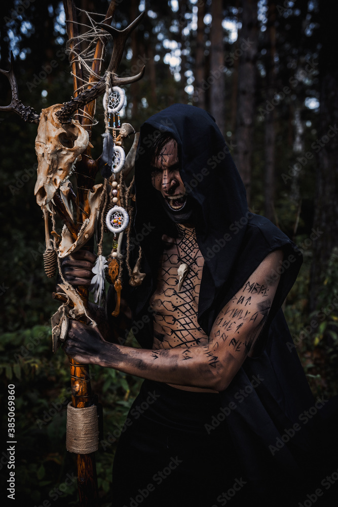 Naklejka premium Sorcerer with marks on his body in the forest