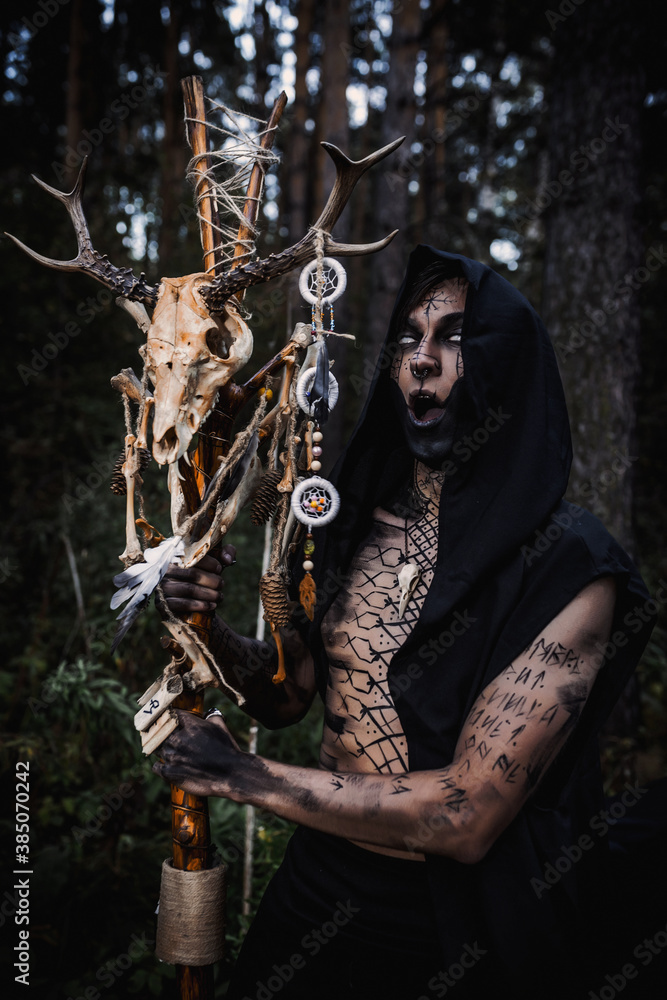 Naklejka premium Sorcerer with marks on his body in the forest