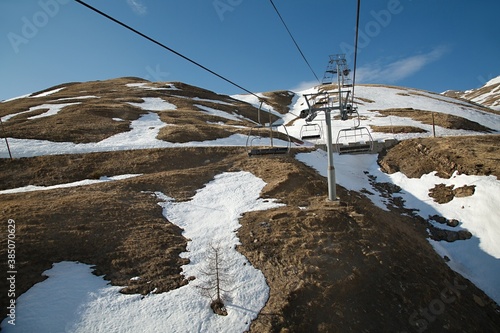 Ski lift in the Alps with lack of snow after heavy melting © Gudellaphoto