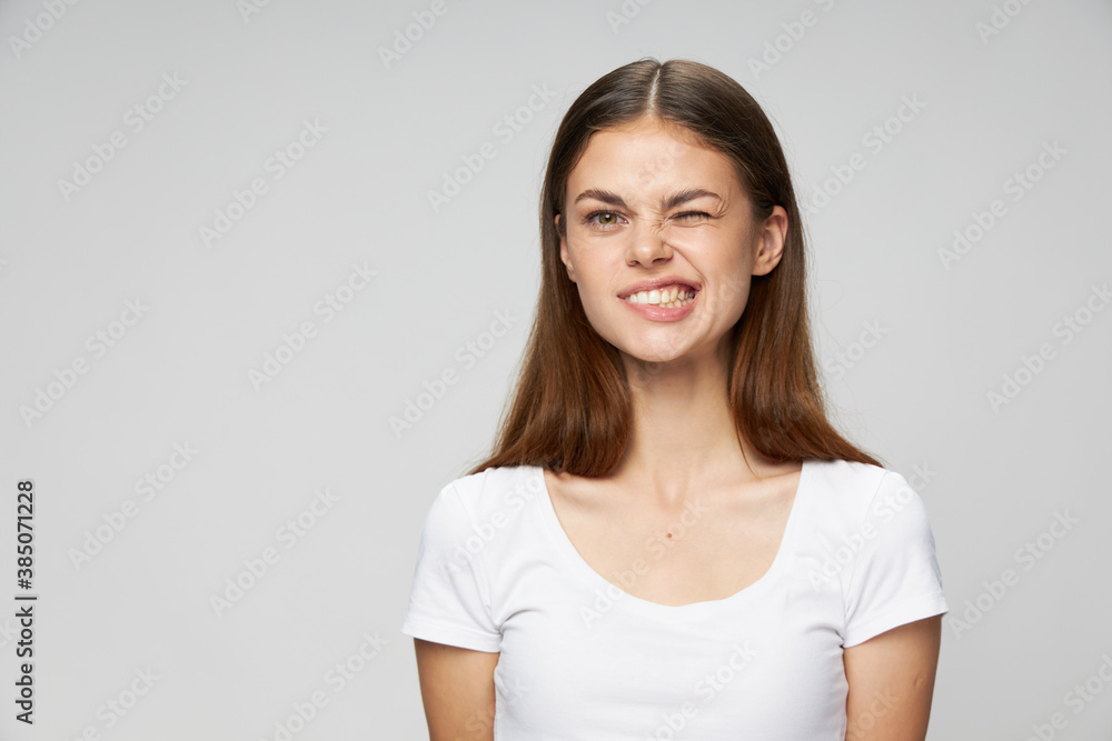 Woman in white t-shirt grimace smile cropped view Woman in white t-shirt grimace smile cropped view