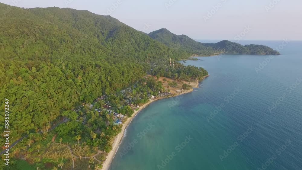 Tropical Island drone spin rotation shot with lush green rain forest and tropical palm trees with white sand beach and rocky coastline. Tropical Island drone spin rotation shot with lush green rain forest and tropical palm trees with white sand beach and rocky coastline.