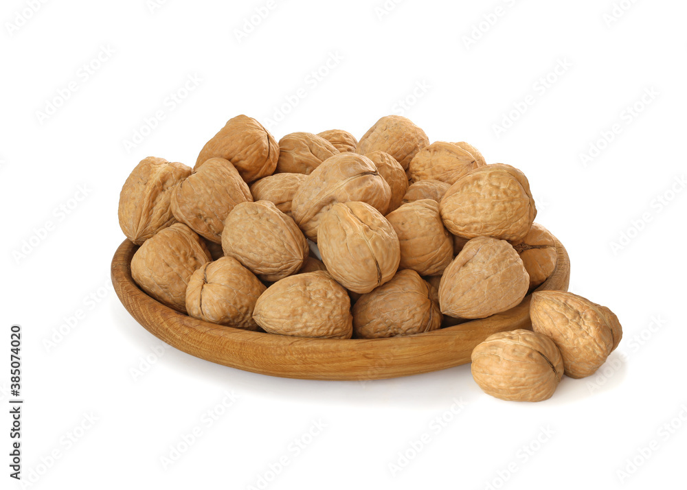 Walnuts in wood plate isolated on the white Walnuts in wood plate isolated on the white