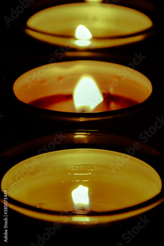 Candles light; candle flames background; selective focus.
