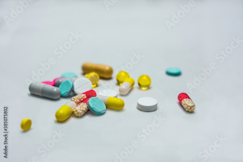 Tablets and capsules are in bulk on a white background