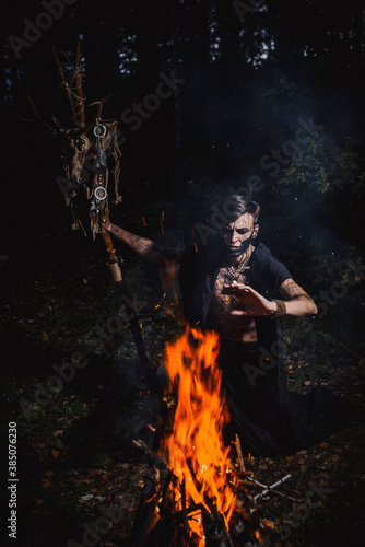 Sorcerer with marks on his body in the forest