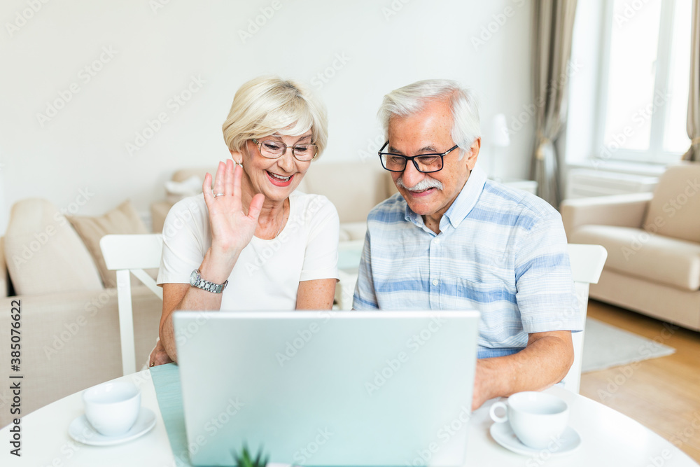 Happy old family couple talking with friends and family using laptop , surprised excited senior woman looking at computer waving and smiling. Happy old family couple talking with friends and family using laptop , surprised excited senior woman looking at computer waving and smiling.