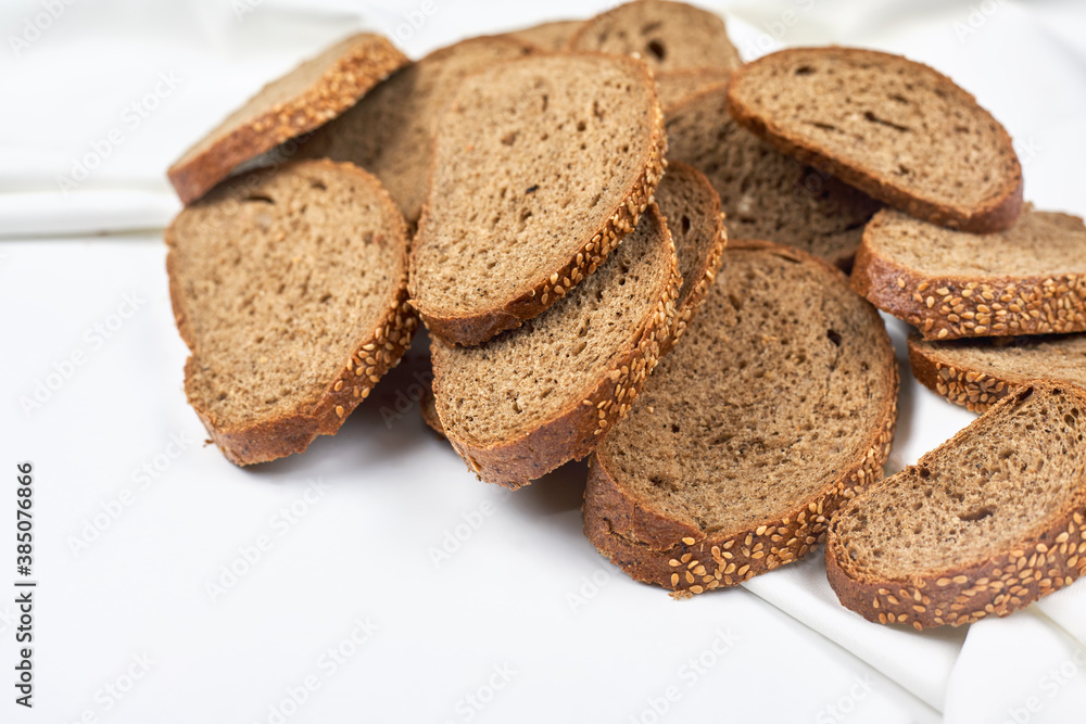 Pile of loaf bread slices on white fabric textile with copy space Pile of loaf bread slices on white fabric textile with copy space