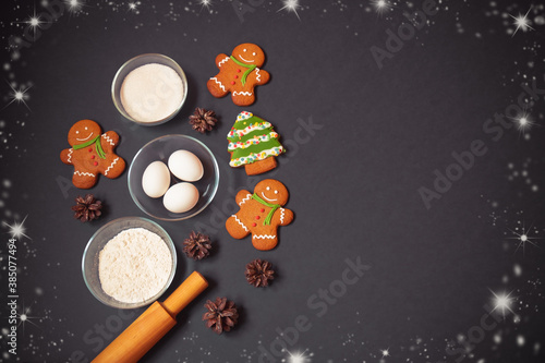 Christmas gingerbread cookies, flour, sugar, eggs and rolling pin. Top view, copy space.
