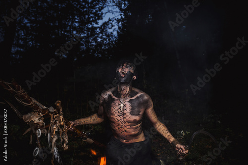 Sorcerer with marks on his body in the forest