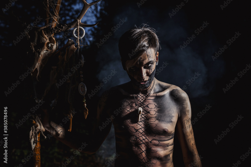 Sorcerer with marks on his body in the forest Sorcerer with marks on his body in the forest