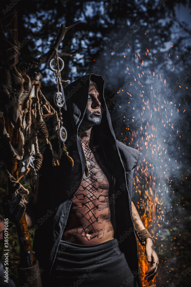 Sorcerer with marks on his body in the forest Sorcerer with marks on his body in the forest