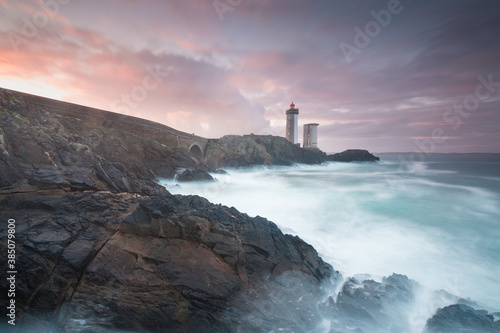 Most popular lighthouse in Europe during stormy weather. Petit Minou Lighthouse at sunset with red light  Brest   France View of Lighthouse of Petit Minou in Brittany. Summer season  France coastline
