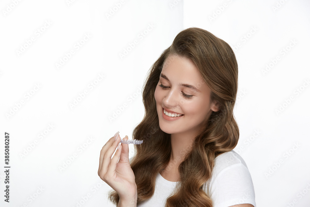 lovely female lookin on tooth cap in her arms and smiling lovely female lookin on tooth cap in her arms and smiling